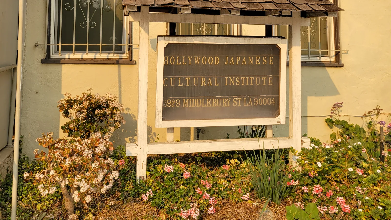Exterior sign for the Hollywood Japanese Cultural Institute at 3929 Middlebury Street, surrounded by the building and garden.