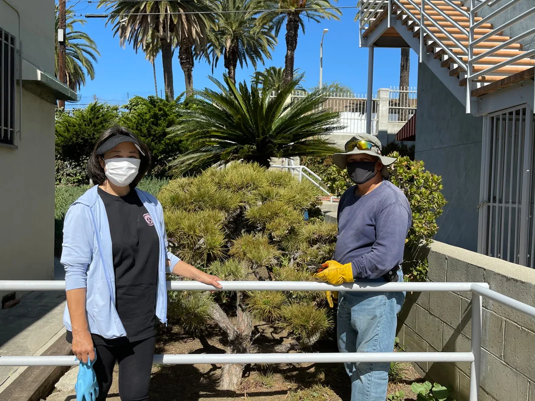 Two people caring for landscaping beside the HJCI facility.