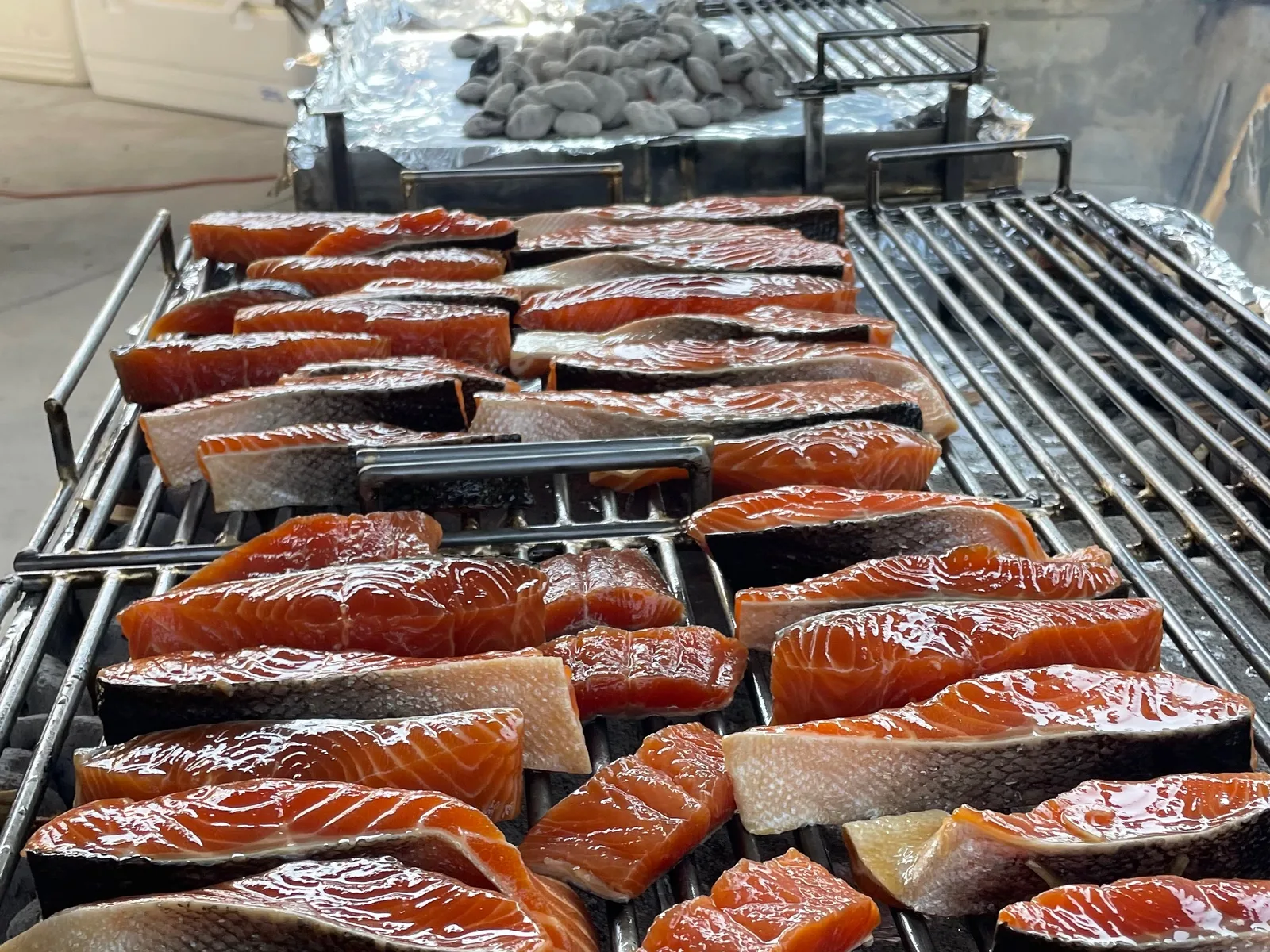 Rows of salmon portions prepared on smoking racks at HJCI